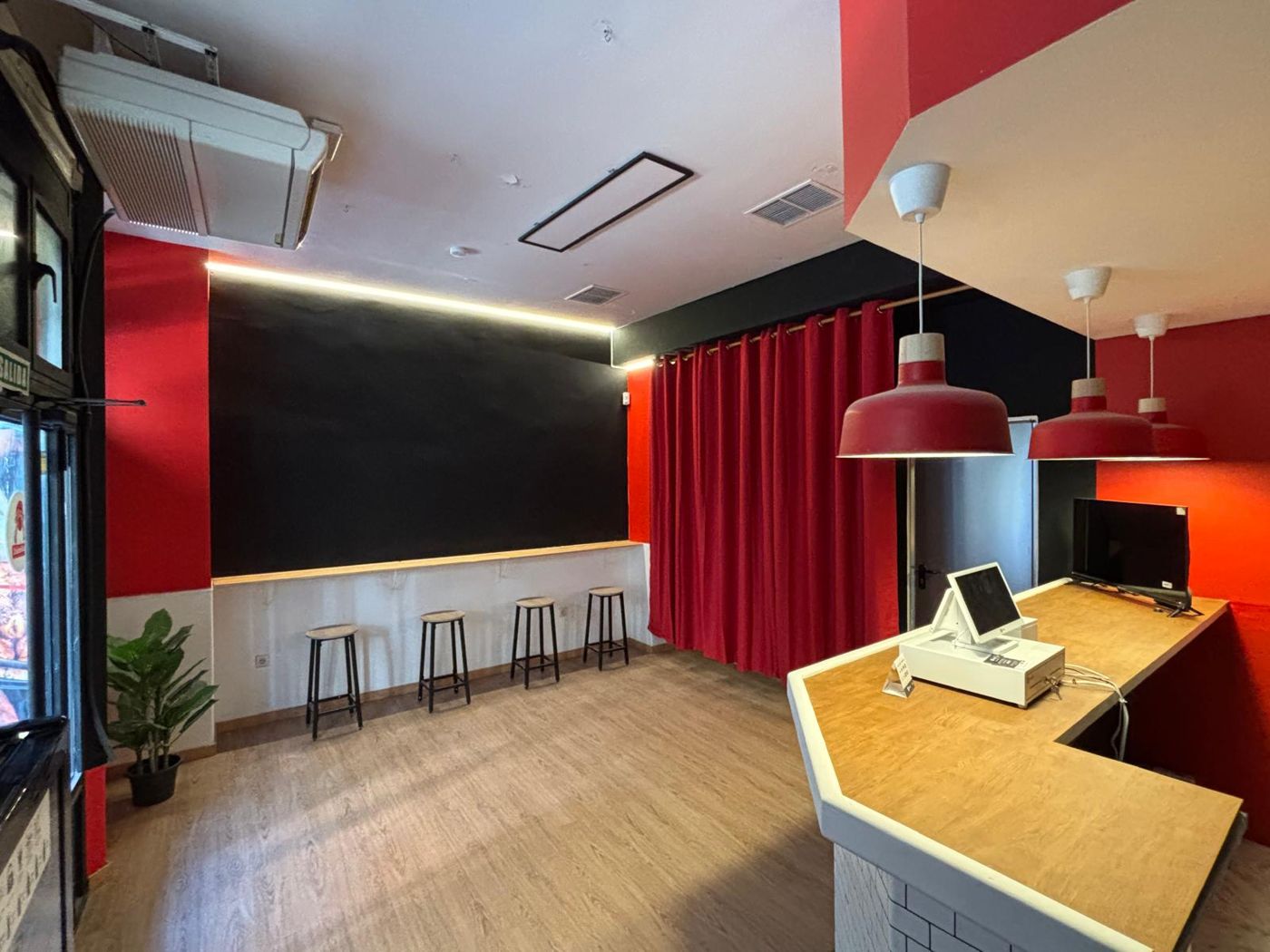 Interior del local con barra y taburetes