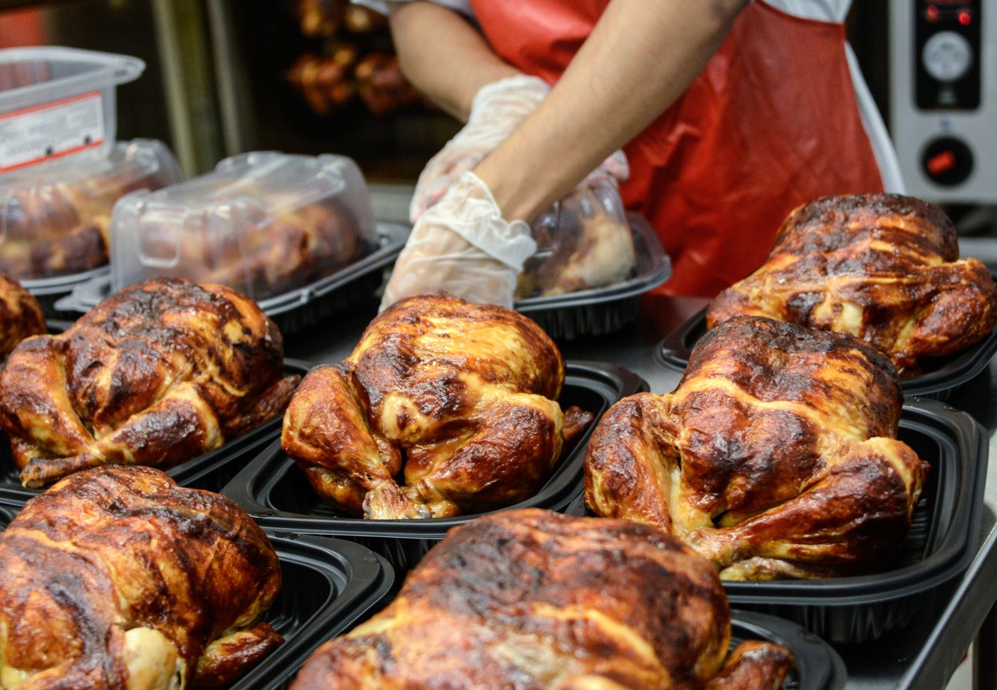 Pollos asados recién salidos, en sus bandejas para llevar